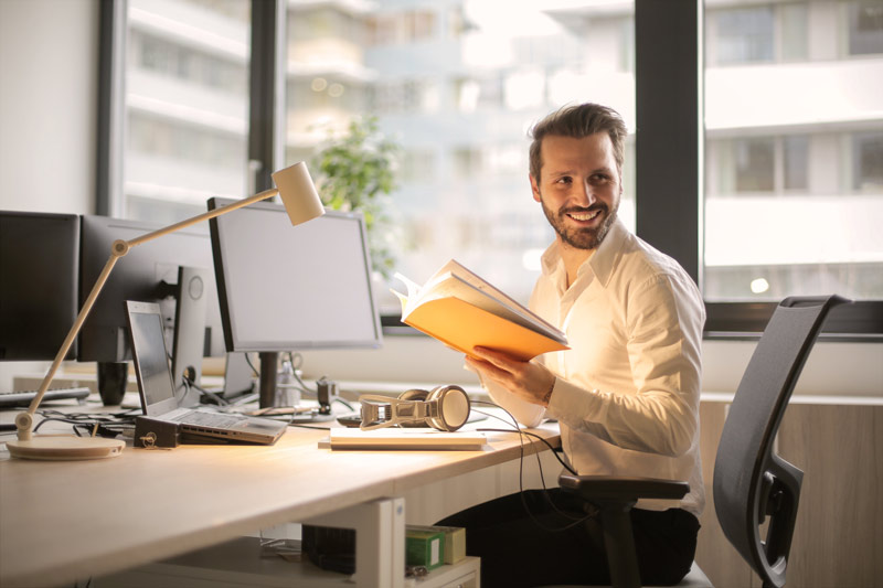 Man met baard lachend achter bureau | Factuur programma PERIFACT voor ZZP en MKB - factuursoftware